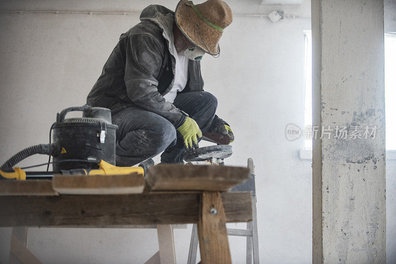建筑工人正在用砂纸打磨墙壁