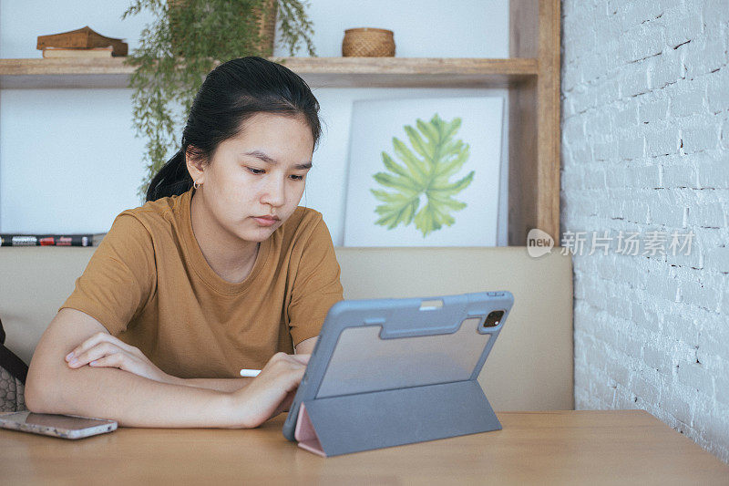 亚洲年轻女学生打算通过数字平板电脑在线学习