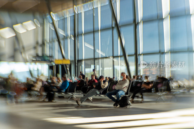 在国际机场候机楼等候航班的旅客。与lensbaby为有意的镜头效果