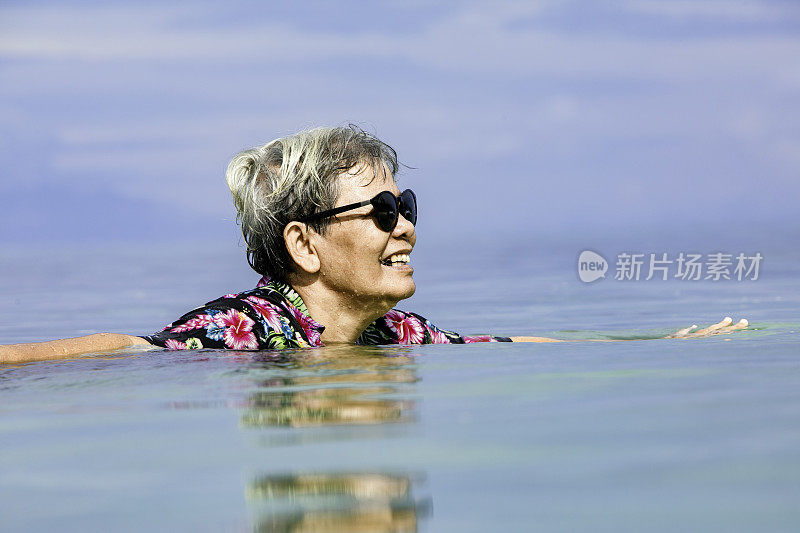 在印度尼西亚东努沙登加拉的纳班巴乔度假期间在海洋中游泳的年长成人