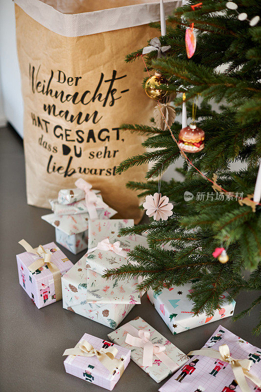 一棵现代装饰的圣诞树，圣诞树下包裹着圣诞礼物