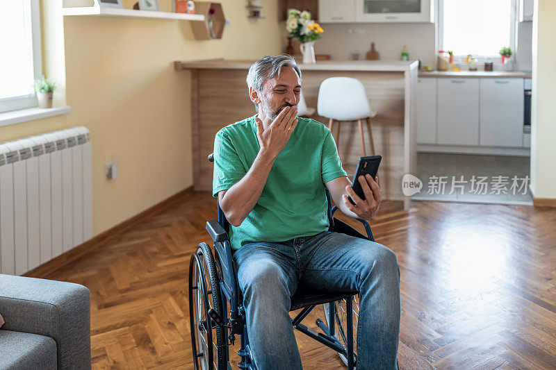 坐在轮椅上的成熟男人在家里与家人进行视频电话会议