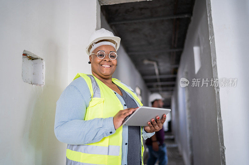一名女性建筑工人在建筑工地使用数码平板电脑