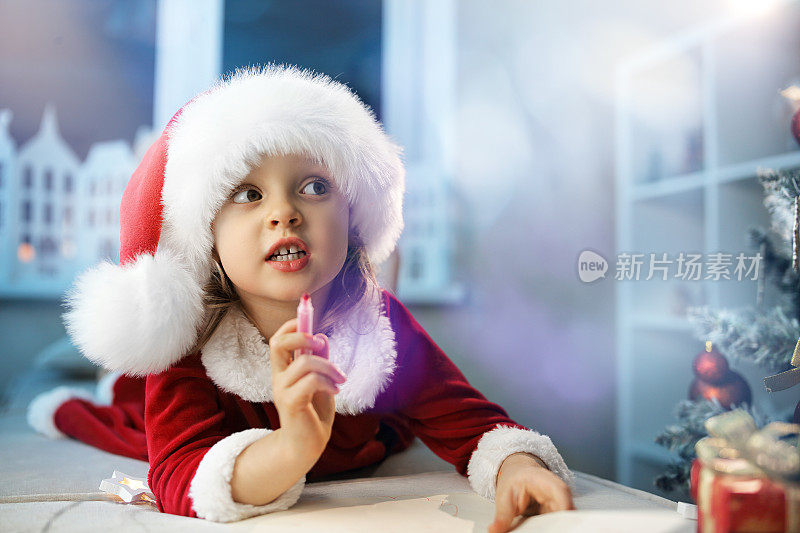 一个可爱的小女孩梦想写一封信给圣诞老人关于一件珍贵的礼物，在她房间的圣诞树旁边