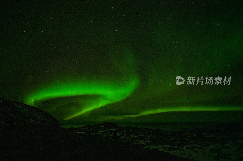 北极光在夜空中山脉的轮廓