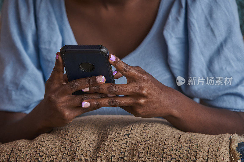 年轻的非洲裔美国妇女在电话上发短信的特写