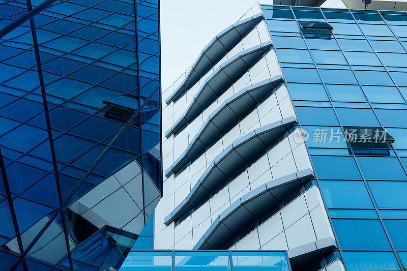 低视角的企业建筑外观与不平的部分在蓝色玻璃