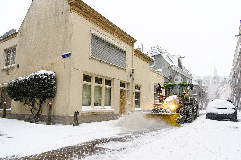 拖拉机用扫雪机和扫雪机清除街道上的积雪