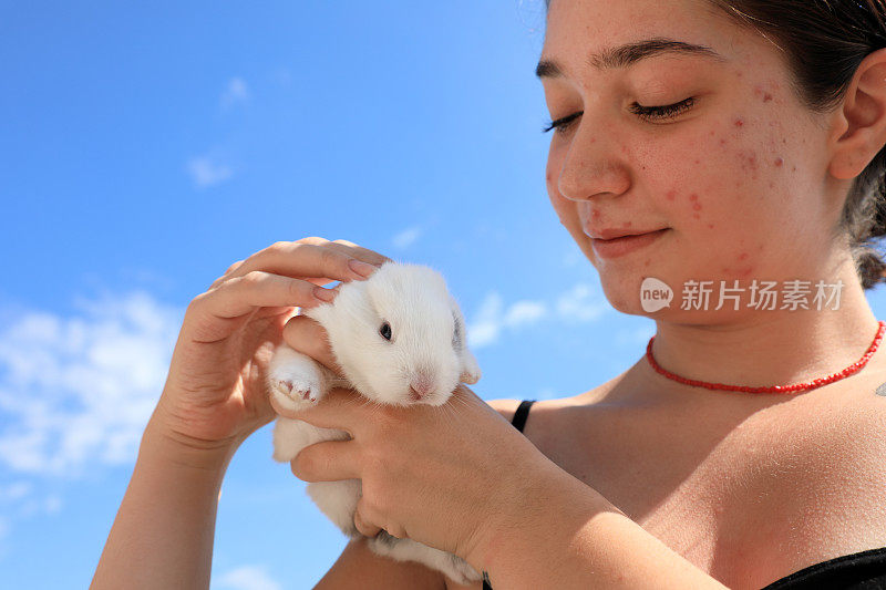 十多岁的女孩手里抱着兔子宝宝的肖像