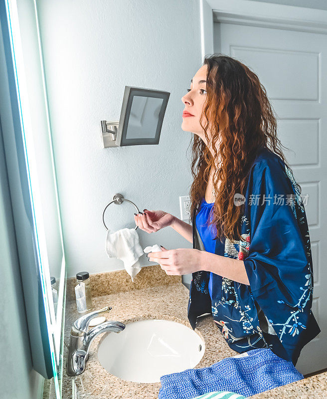 女人在家庭浴室里，每天早晚照镜子，涂乳液