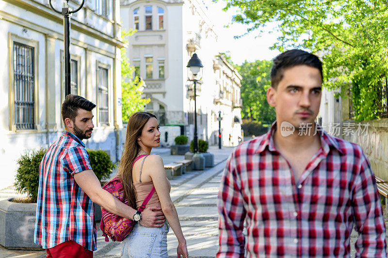 一个年轻的女人和她的男朋友在城市里散步时制造了一个嫉妒的局面