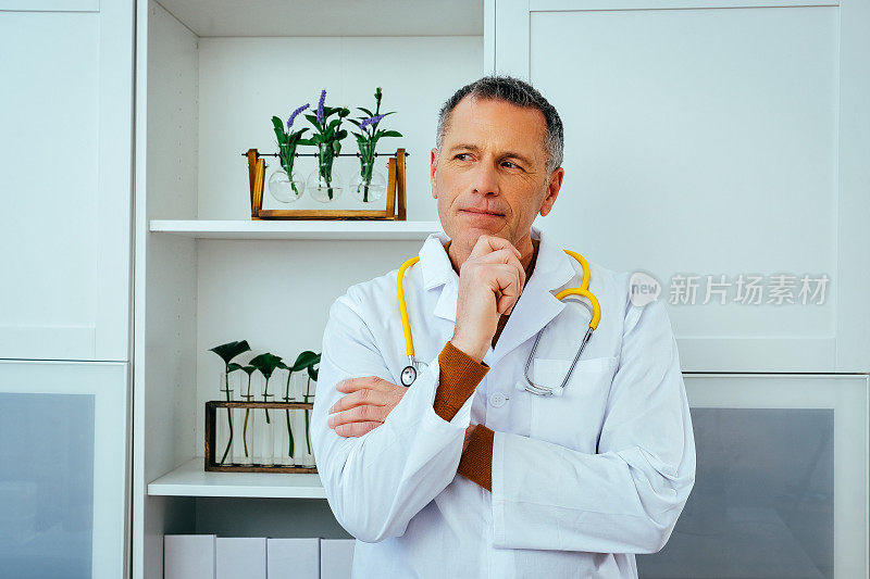 近距离肖像沉思深思的男性医生医生在实验室大衣与听诊器看向别处