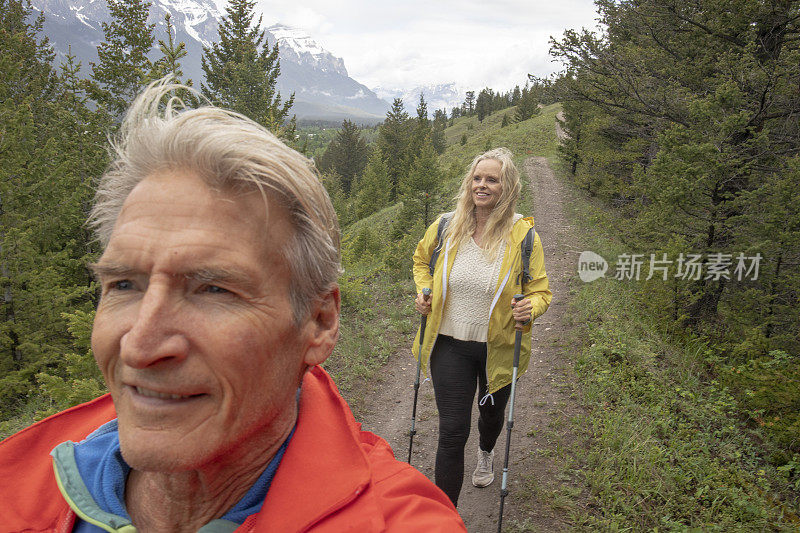 成熟的夫妇沿着山脊徒步旅行