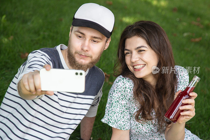 一个年轻的男人和女人在野餐，户外娱乐自拍。