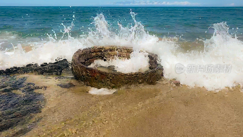 海浪拍打着废弃的船只部件