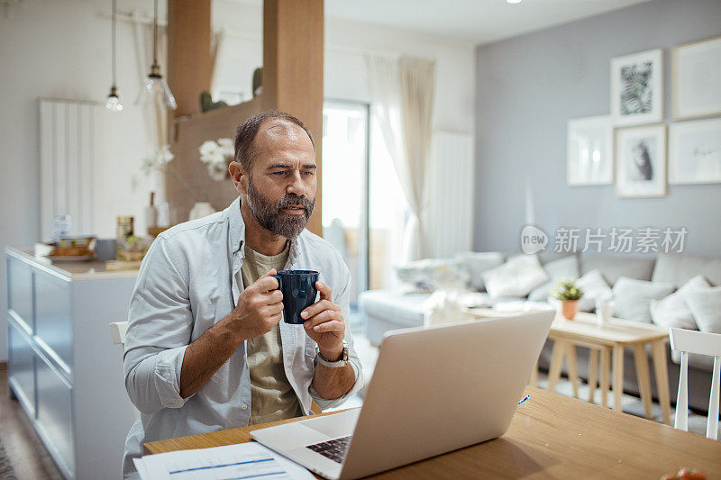 一个中年男人在早上检查他的家庭财务状况