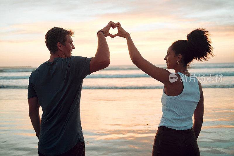 海滩，情侣和心手在日落，快乐的人们在墨西哥度假时聚在一起。关心，爱和信任，在跨种族的浪漫关系与享受海洋天空黄昏。