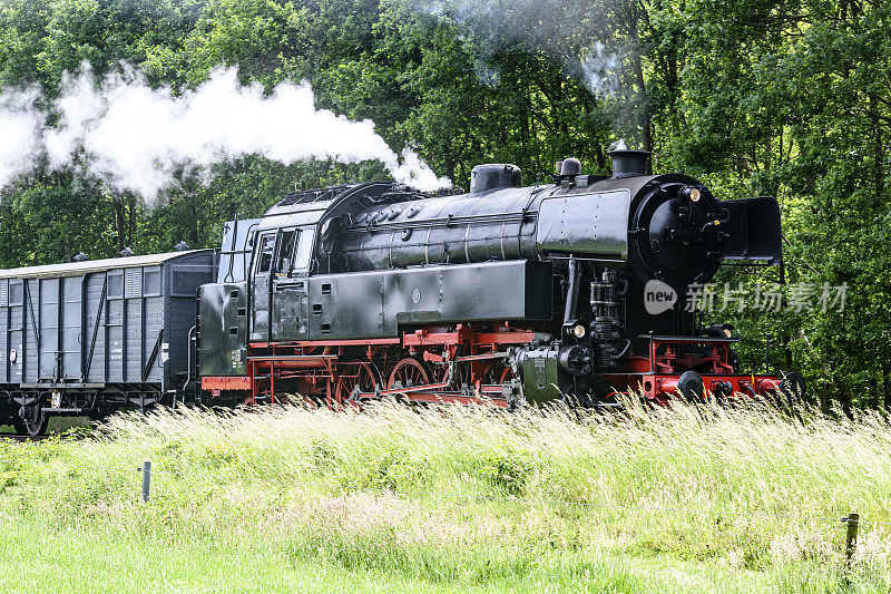 蒸汽火车带着火车头的烟雾行驶在乡间