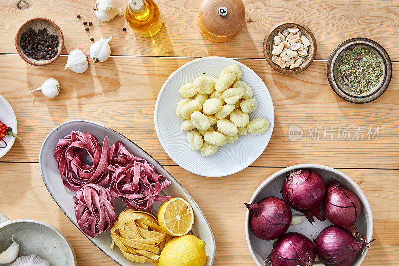 意大利面和汤圆加上香草和香料，食物准备在厨房的桌子上