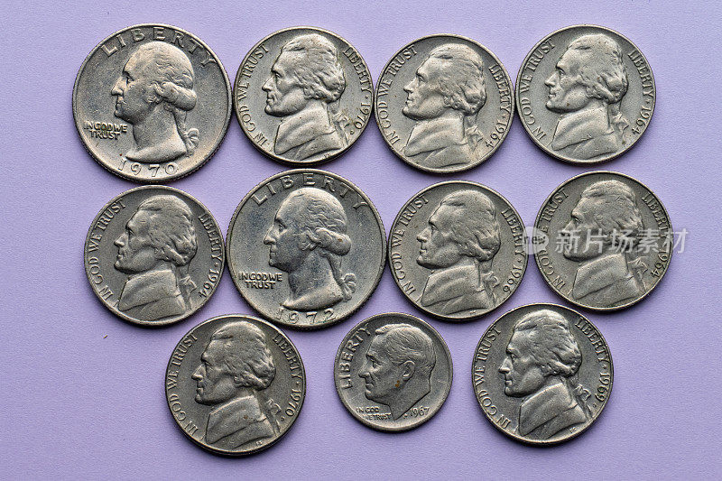 各种各样的旧镍币，一角硬币和四分之一的紫色背景硬币。
