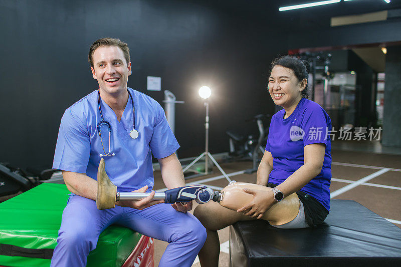 物理治疗师照顾病人和她的义肢。理疗师在体育中心帮助残疾妇女安装义肢。康复和健身房与物理治疗师和病人一起工作