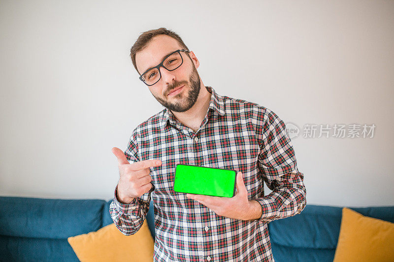一名男子手持绿屏手机的画像