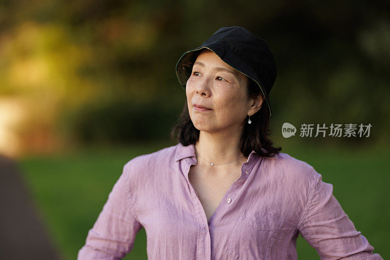 一个戴着帽子的亚洲女人在户外望着远方
