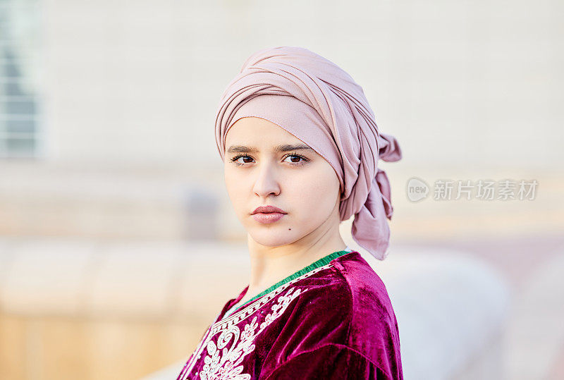 一位戴着头巾的年轻穆斯林妇女在街上的肖像