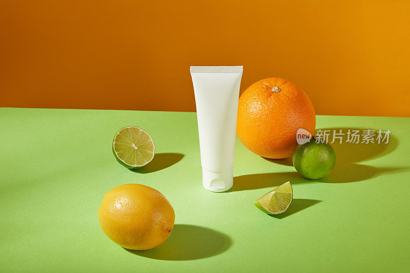前面的视图在框架柑橘类水果具未标记管在中心，在橙色背景上。用复制空间模拟化妆品