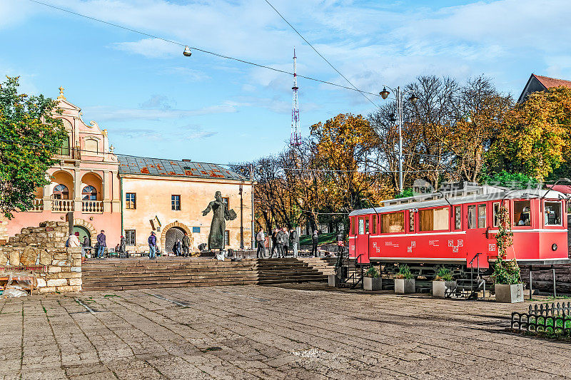 一个秋天的早晨，在利沃夫的二手图书市场上，一辆粉红色的有轨电车靠近伊万·费多罗夫雕像