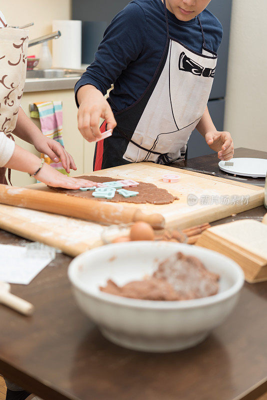 少女和男孩用饼干模具做饼干