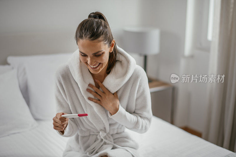 年轻女子微笑着接受怀孕测试