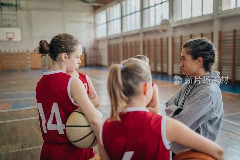 年轻女孩和她们的女篮教练在训练