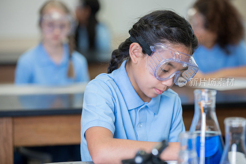 亚洲小学女孩在科学化学实验室学习作业