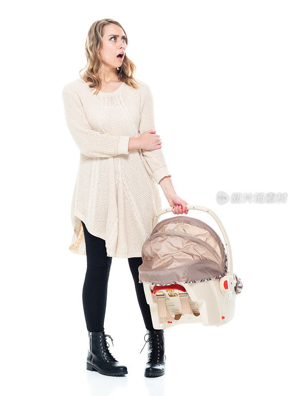 年轻漂亮的妈妈穿着毛衣抱着婴儿汽车座椅，震动