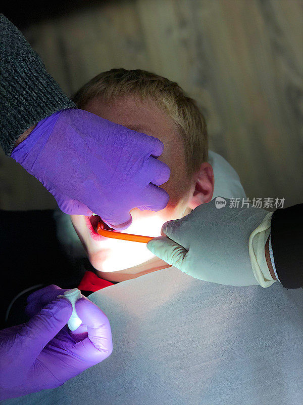 牙医正在修理男孩的牙齿