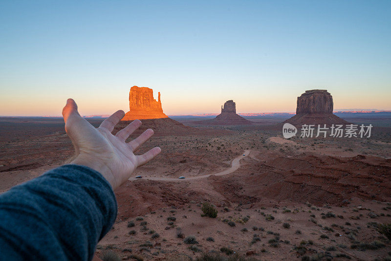 手伸向日落在纪念碑谷在美国，旅游概念