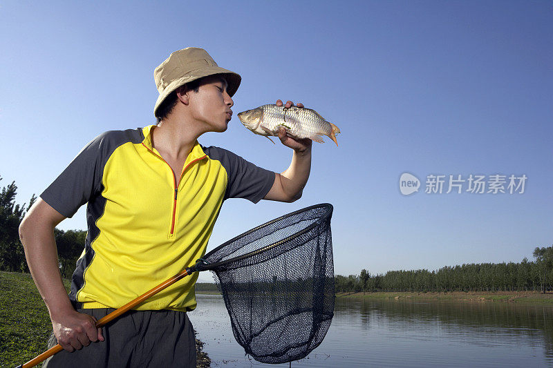 年轻男子在河边捕鱼