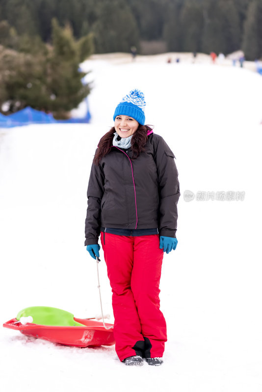 快乐的女人微笑着在雪地上滑雪，冬天的背景