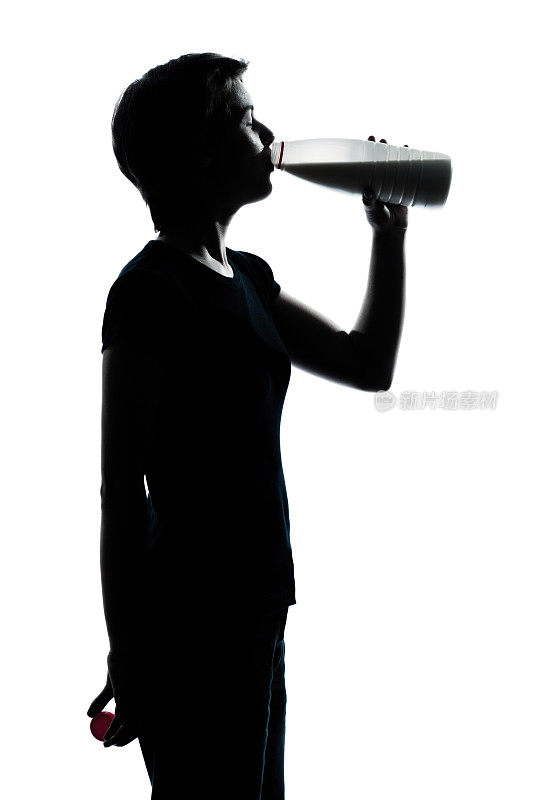 一个年轻的男孩或女孩喝牛奶剪影