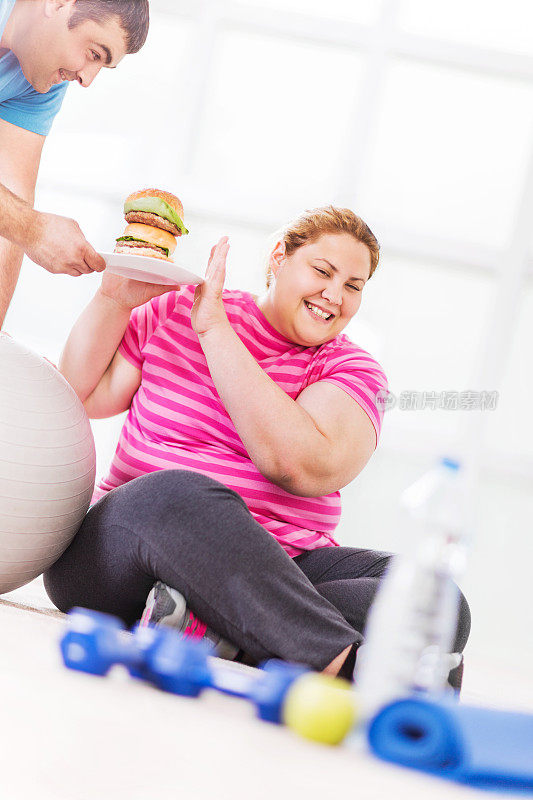 胖女人拒绝吃汉堡。