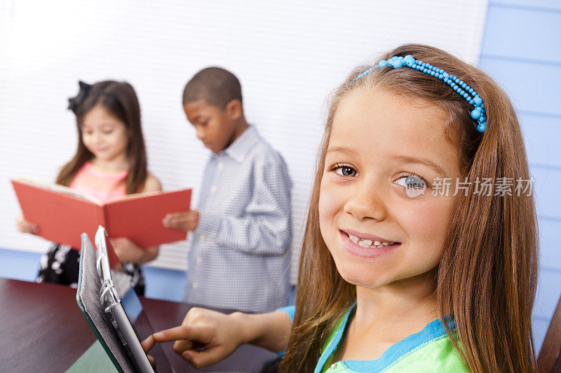 小学的学生。男孩，女孩，拿着书，平板电脑。教室。