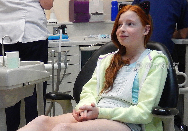 焦虑的女孩坐在牙医椅上，牙痛，牙齿，牙科预约