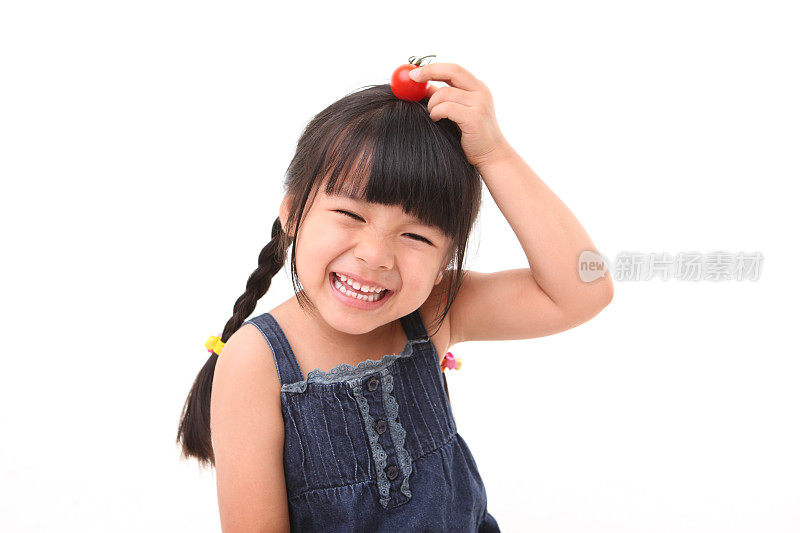 快乐的女孩玩着新鲜的樱桃番茄
