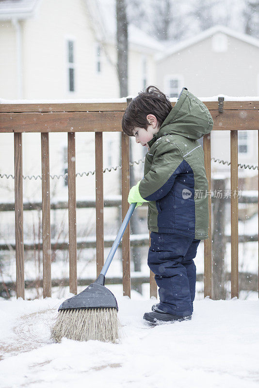 小男孩在清理桌子上的雪