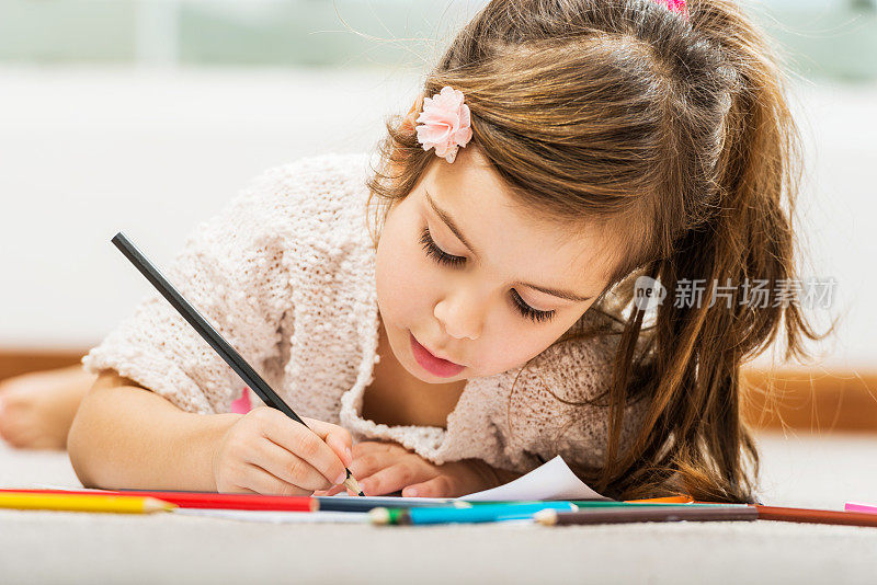 小女孩用蜡笔画画。