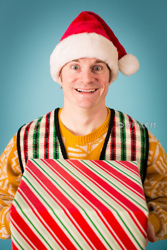 男人戴着圣诞帽和丑陋的毛衣拿着圣诞礼物