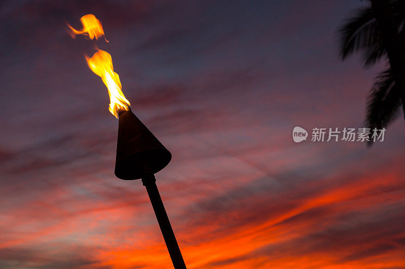 夏威夷考艾岛日落热带海滩上的火炬燃烧