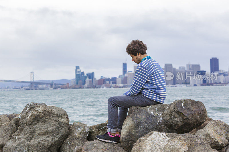 年轻的潮男站在旧金山的景色前。