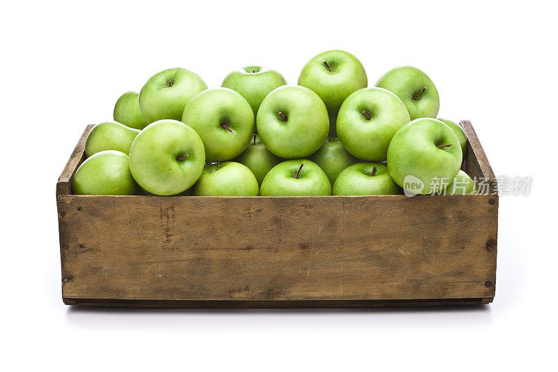 绿苹果装在木箱里，白色背景上孤立